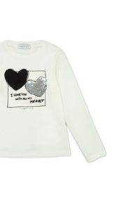 Camicia bianca a maniche lunghe con una grafica raffigurante due cuori—una nera e una in paillettes argento—con il testo che recita “TI AMO CON TUTTO IL MIO CUORE.”