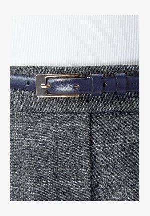 Grijze textuurstof van een broek met een marineblauwe leren riem met een gouden metalen gespsluiting. De riem heeft een gladde afwerking en verstelbare gaten.