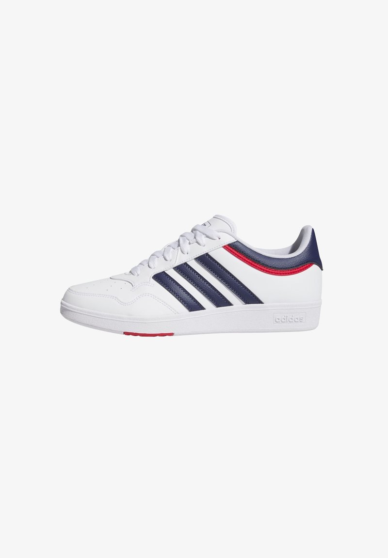 White athletic shoes with three navy stripes, red accents on the side, perforated details on the toe, and a textured rubber sole.