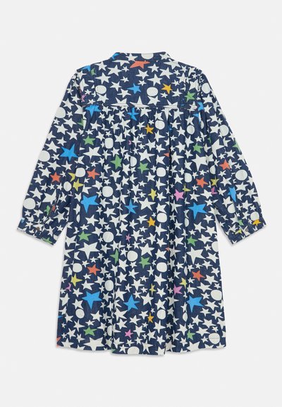 Μπλε υφασμάτινο φόρεμα με σχέδιο από πολύχρωμα αστέρια και κύκλους, με μακριά μανίκια και λεπτομέρεια κουμπιού στον καρπό.