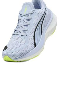 Zapatilla deportiva azul claro con parte superior de malla, acentos en negro, suela acolchada y suela exterior en verde neón. Presenta un diseño elegante y un sistema de cordones.