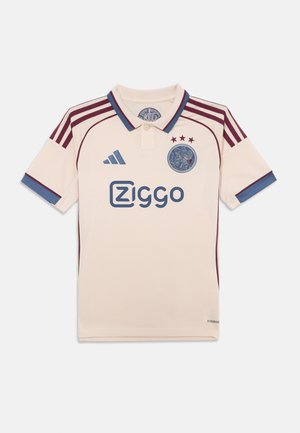 Maillot de football couleur crème avec des accents bordeaux et bleu, doté d'un col polo, de trois étoiles et d'un logo central.