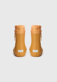 Bottes de pluie jaunes à la cheville, texture mate, col rembourré avec élastique, fermeture éclair latérale et accents réfléchissants blancs à l'arrière.