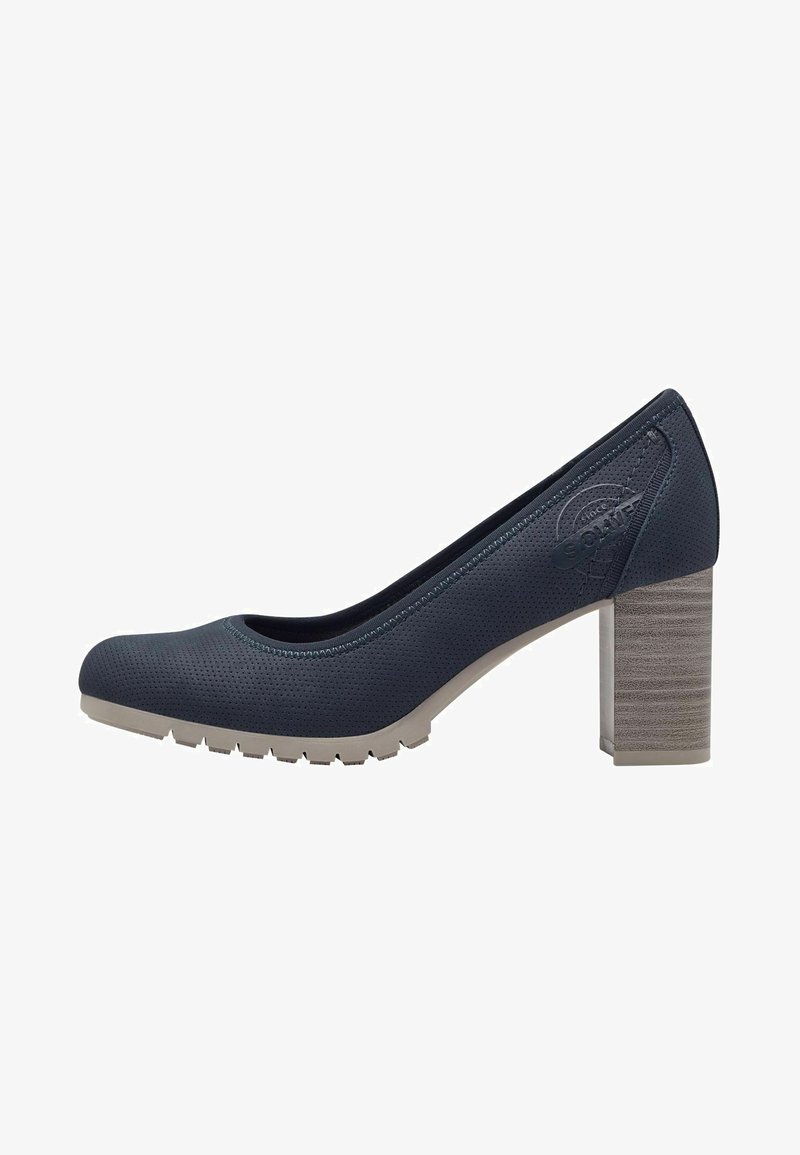 Zapato de tacón perforado de color azul oscuro con punta redonda, suela de goma beige y un tacón bloque de altura media texturizado. Presenta un sutil logo en la parte posterior.