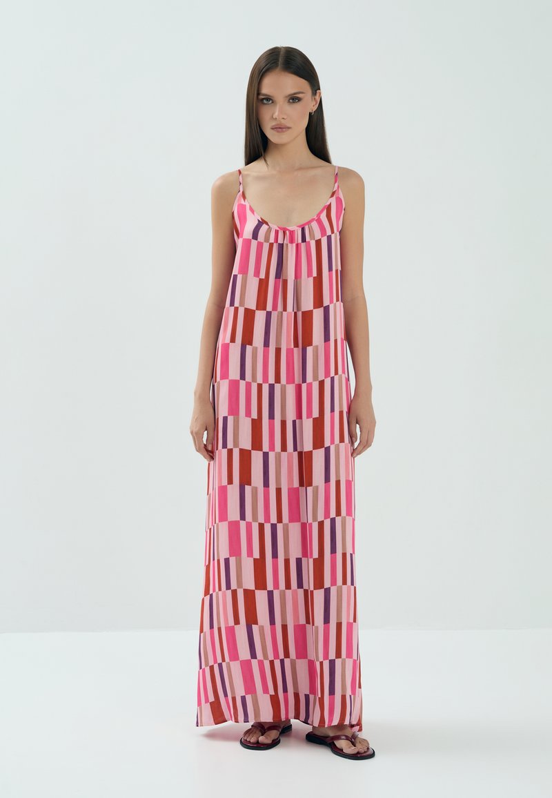 Maxi sukienka w intensywnym różowym materiale, zdobiona geometrycznym wzorem w pionowe paski w kolorze czerwonym, fioletowym i jasnoróżowym. Ramiączka typu spaghetti.