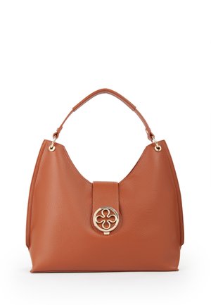 Sac à main en cuir marron avec une poignée courte et unique et un fermoir circulaire doré décoratif avec un motif en forme de fleur à l’avant.