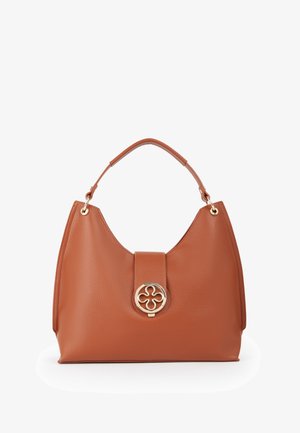Sac à main en cuir marron avec une poignée courte et unique et un fermoir circulaire doré décoratif avec un motif en forme de fleur à l’avant.