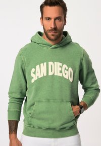 Felpa verde in tessuto morbido, con tasca frontale e scollatura rotonda. "SAN DIEGO" stampato in bianco sul petto.