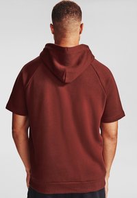 Krótki rękaw, kaptur w ciemnoczerwonym kolorze, wykonany z miękkiego materiału. Posiada raglanowe rękawy oraz ściągacz u dołu, co zapewnia luźny fason.
