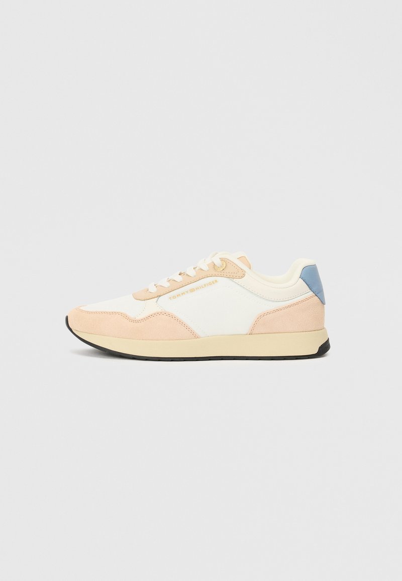 Sneaker med en hvid base, lyse ferskenfarvede ruskindsdetaljer og en lyseblå hælflap. Snørebånd i matchende farve med en gummisål.