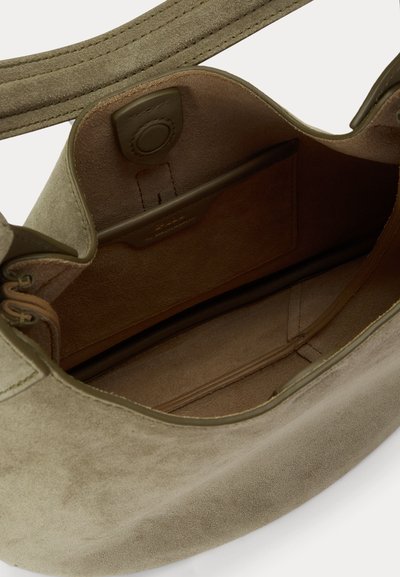 Ξεκούμπωτη τσάντα από καστόρι σε ελαιώδες πράσινο χρώμα, που δείχνει το εσωτερικό φόδρι από καστόρι με μια μικρή τσέπη και κλείσιμο με μαγνητικό κουμπί.