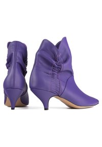 Paarse leren enkelboots met een geraffineerd ontwerp, spitse neus en een lage kittenhak. Kenmerkt zich door contrasterende stiksels langs de naden.