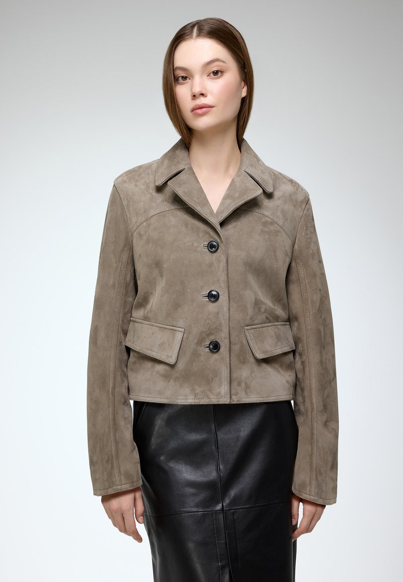 Khaki suede cropped jacket with a notched collar, front button closure, and two flap pockets. Smooth texture with a tailored fit.