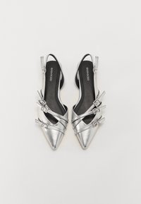 Stříbrné metalické slingback boty s špičatými špičkami, které mají tři dekorační popruhy s přezkami, hladký povrch a černé stélky.