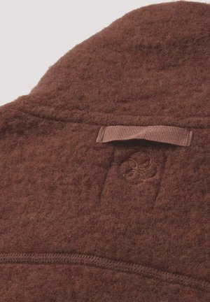Brown felted wool garment with a textured surface. Features a small embroidered logo and a woven loop tag for hanging.