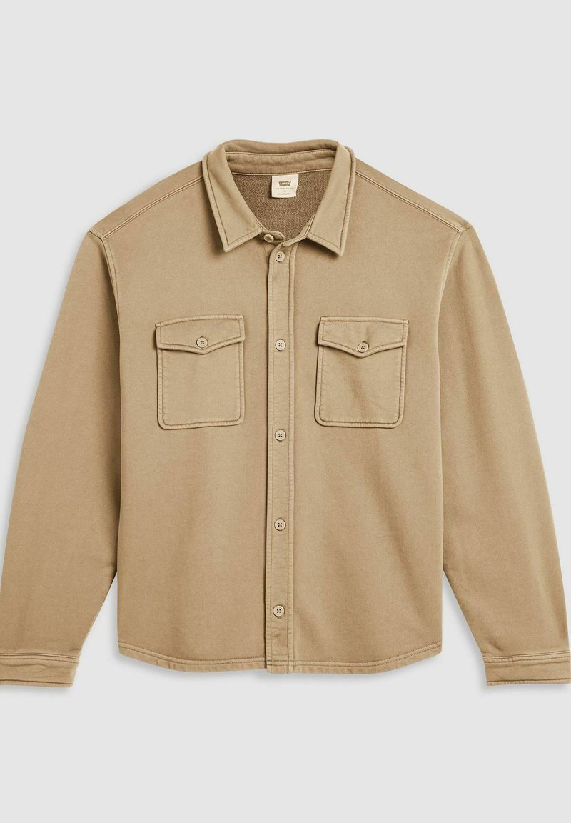 Beige overhemd met knopen, gemaakt van zachte stof, met twee borstzakken, een kraag en gestikte accenten langs de schouders en zoom.