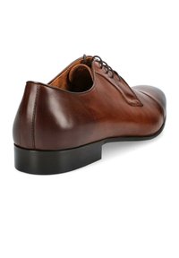 Brązowe skórzane buty zapinane na sznurowadła o gładkim wykończeniu, lekko zaokrąglonym nosku i czarnej gumowej podeszwie. Widoczne detale szwów wzdłuż krawędzi.