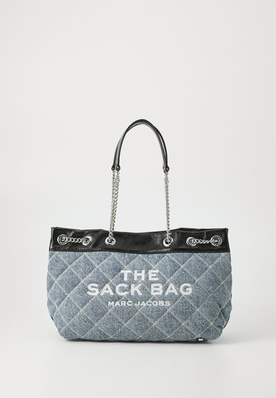Gepolsterte Denim-Tote mit schwarzem Lederoberteil und silbernen Kettenakzenten. Enthält weißen Drucktext: "DER SACK BEUTEL MARC JACOBS."