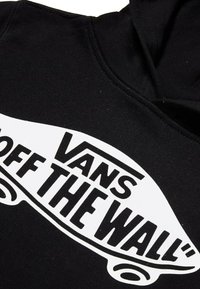 Felpa nera con cappuccio caratterizzata da un'importante grafica bianca con il testo "VANS OFF THE WALL", che mette in risalto un tema legato allo skate.