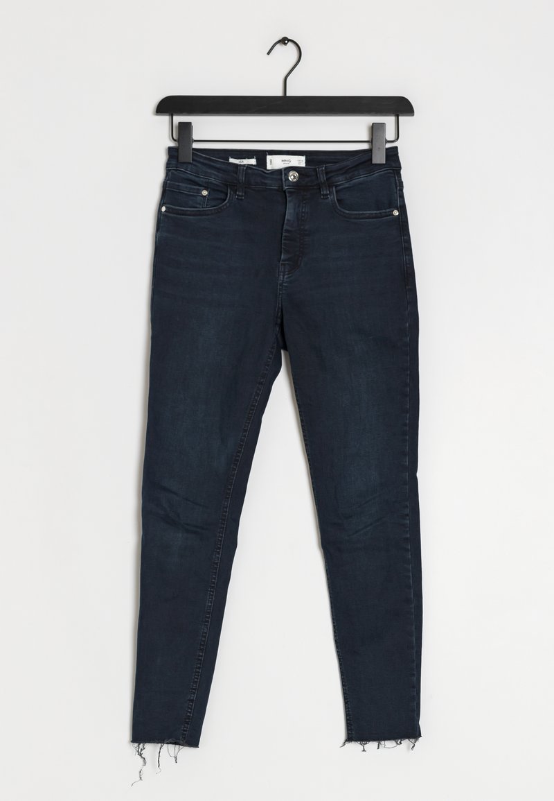 Jeans skinny de color azul oscuro con dobladillo deshilachado, hechos de mezclilla, que cuentan con bolsillos delanteros y una cremallera con cierre de botón.