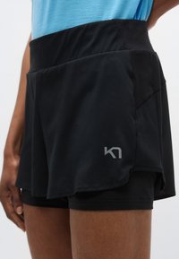 Μαύρα αθλητικά σορτς με ψηλή μέση, που διαθέτουν πολυεπίπεδο σχέδιο, διαπνέον ύφασμα με οπές και ασημένιο λογότυπο στο πλάι.