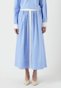Falda larga azul hecha de tejido ligero con rayas blancas verticales. Cuenta con una cintura elástica y un cierre frontal con botones, acompañada de puños blancos.
