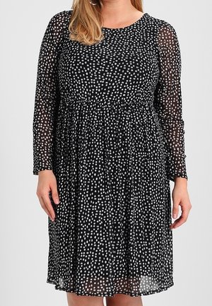 Black polka dot dress with long sheer sleeves, a round neckline, and an elastic waist. Lightweight fabric with a flowing silhouette.