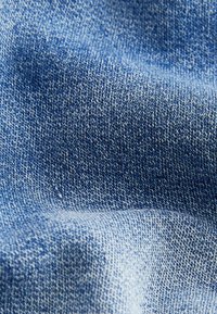 Denim tkanina z gladko, teksturirano površino v različnih odtenkih modre, s klasičnim twill tkanjem, blagim zbledelostjo in brez vidnih okrasnih elementov.