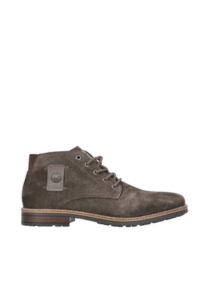 Braune Wildleder-Stiefeletten mit runder Zehenform, braunen Schnürsenkeln und einer strukturierten Gummisohle. Enthält ein Logo-Patch an der Seite und eine gestickte Akzentuierung.