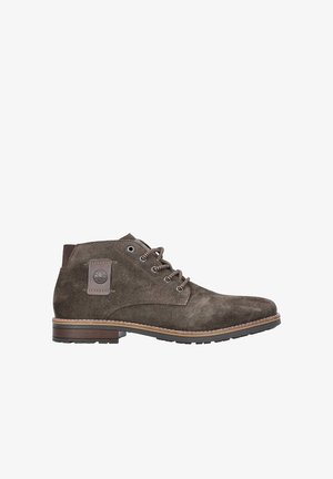 Braune Wildleder-Stiefeletten mit runder Zehenform, braunen Schnürsenkeln und einer strukturierten Gummisohle. Enthält ein Logo-Patch an der Seite und eine gestickte Akzentuierung.