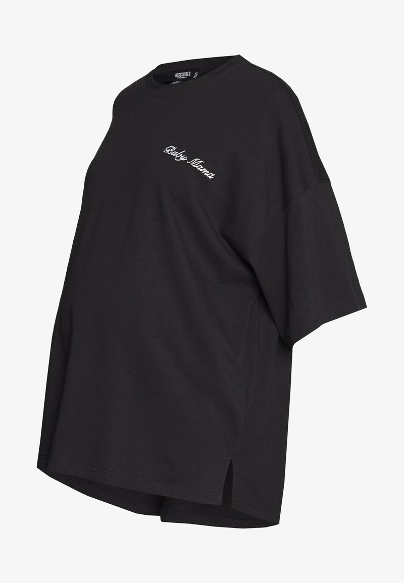 T-shirt de maternité noir oversize à manches courtes avec un texte blanc en cursive « Baby Mama » sur la poitrine et des fentes latérales à l'ourlet.