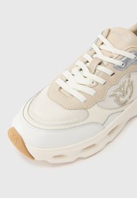 Μπέζ και λευκό αθλητικό παπούτσι με υλικά από δίχτυ και δέρμα, υφή ανάγλυφη, παχύ πέλμα και κεντημένη λεπτομέρεια λογότυπου.