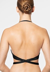 Soutien-gorge bikini noir à halter avec fines bretelles, fermeture au dos réglable, texture lisse et design minimaliste.