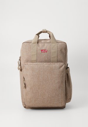 Mochila de tela beige con dos asas en la parte superior, bolsillo con cremallera en el frente, bolsillo de malla en el lateral y parche del logo rojo de Levi's en la parte frontal.