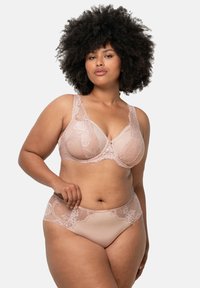 Biustonosz w kolorze różanym, ozdobiony koronką, z szerszymi ramiączkami i kwiatowymi akcentami, w komplecie z dopasowanymi figami bikini. Półprzezroczysty fason wykonany z miękkiego materiału.