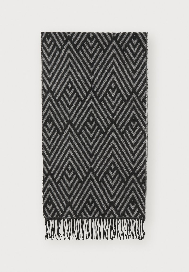 Couverture noire et grise à motifs présentant des lignes géométriques en zigzag avec des bords frangés, fabriquée en tissu doux à texture lisse.