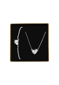 Zilveren sieraden set bestaande uit een hartvormige ketting met hanger en een bijpassende armband, tentoongesteld in een zwarte doos met een gouden rand.