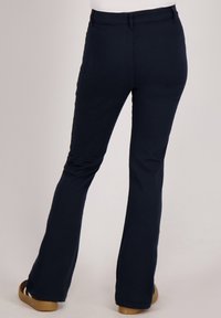 Marineblauwe uitlopende broek van glad, rekbaar materiaal, met een klassieke tailleband en minimale stikdetails aan de achterkant.