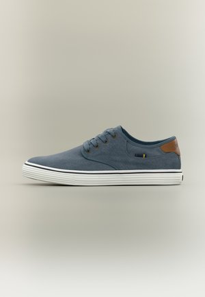 Μπλε πάνινο παπούτσι χαμηλού ύψους με λευκή λαστιχένια σόλα, καφέ επιφάνεια στη φτέρνα και κορδόνια κλεισίματος σε ουδέτερο φόντο.