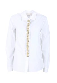 Camicia bianca con bottoni e maniche lunghe, caratterizzata da un'ornamentazione decorativa gialla e trasparente lungo la patta frontale. Tessuto liscio.