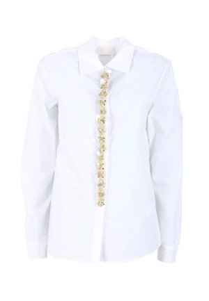 Camicia bianca con bottoni e maniche lunghe, caratterizzata da un'ornamentazione decorativa gialla e trasparente lungo la patta frontale. Tessuto liscio.