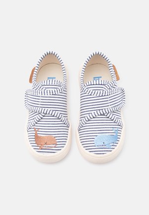 Chaussures pour tout-petit avec des rayures bleu marine et blanches, une baleine marron à gauche et une baleine bleue à droite, chacune avec une seule bride en velcro.