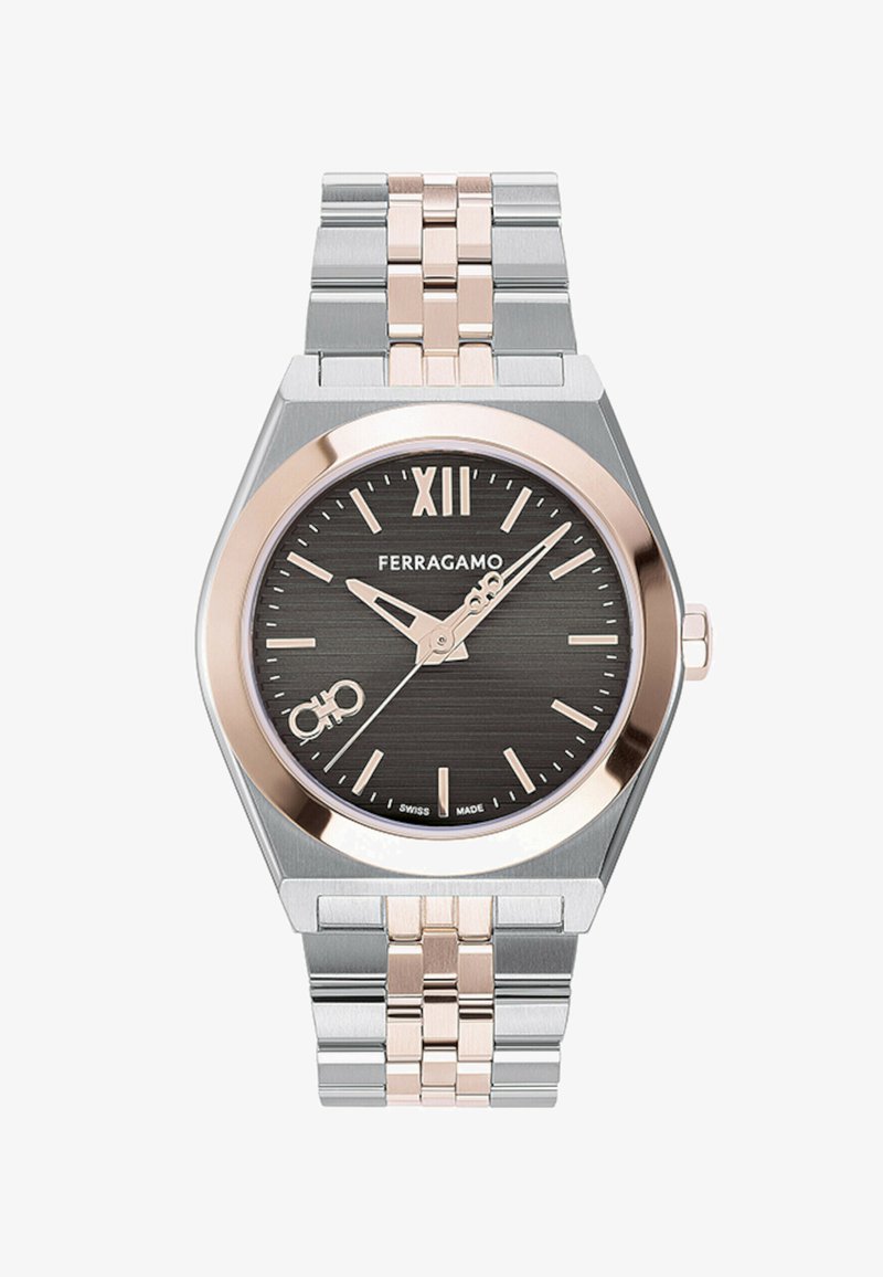 Hõbedane ja roosa kuldne metallkell kuuekülgse kellanäidikuga, musta tekstuuriga sihverplaat, roosa kullaga tundemärgid ning hõbedane ja roosa kuldne link-käevõru.