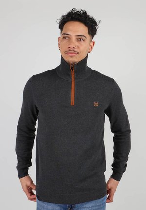 Sweat à fermeture éclair gris foncé avec un col haut et un accent de fermeture éclair orange. Présente une texture côtelée et une broderie de logo sur la poitrine.