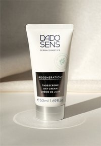 White plastic tube with a silver base, labeled "DADO SENS DERMAcosmetics." Features black text for "REGENERATION" and cream details. 50 ml.