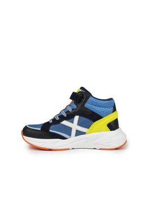 Zapatilla alta en azul marino, azul y amarillo con acentos en blanco. Presenta una parte superior con patrón, un cuello acolchado y una suela blanca gruesa.