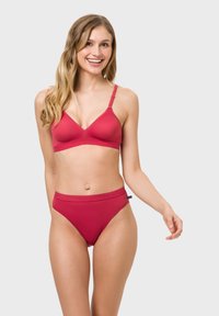 Red bra and high-waisted brief set with smooth texture and adjustable straps, featuring a minimalistic design and logo detail on the waistband.