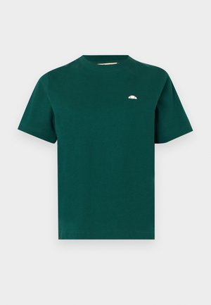 Sötétzöld, rövid ujjú, kerek nyakú póló kisméretű fehér, félkör alakú logóval a bal mellrészen, sima világos háttér előtt.