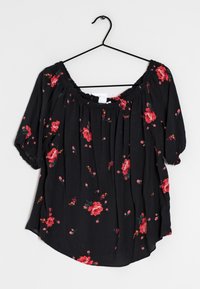 Black floral blouse with short, puffed sleeves. Features red roses and small flowers on a sheer fabric. Elastic neckline with a loose fit.