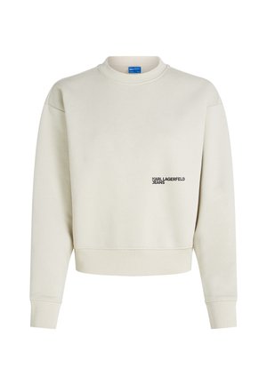 Maglione crema con polsini e orlo a coste, caratterizzato da un piccolo logo nero "KARL LAGERFELD JEANS" sulla parte sinistra del petto.
